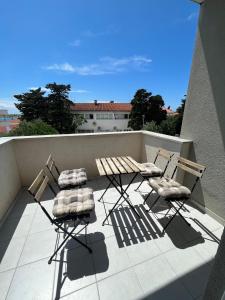 2 sillas y una mesa en el balcón en Apartments Karma en Novalja