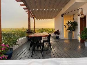 eine Holzterrasse mit einem Tisch und Stühlen auf dem Balkon in der Unterkunft Ultravioleta Boutique Residences in Cabarete