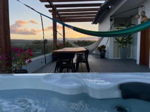 a hot tub on a balcony with a table and chairs at Ultravioleta Boutique Residences in Cabarete