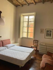 a bedroom with a bed and a window and a chair at Casa Bonacini in Reggio Emilia