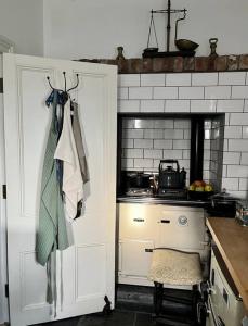 eine Küche mit einer weißen Tür und einem Herd in der Unterkunft Traditional Donegal house on the Wild Atlantic Way in Burtonport