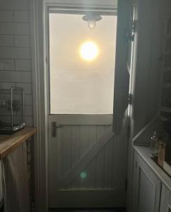 ein Bad mit einem Fenster und einer Tür mit einem Fenster in der Unterkunft Traditional Donegal house on the Wild Atlantic Way in Burtonport