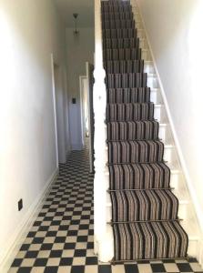 a staircase in a house with a checkered floor at Traditional Donegal house on the Wild Atlantic Way in Burtonport