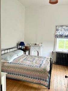 Schlafzimmer mit einem Bett und einem Fenster in der Unterkunft Traditional Donegal house on the Wild Atlantic Way in Burtonport
