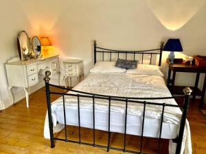 1 dormitorio con cama, tocador y espejo en Traditional Donegal house on the Wild Atlantic Way en Burtonport