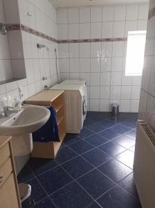 uma casa de banho com um lavatório e uma cama num quarto em Gästehaus Atrico Haus 7 em Neubörger