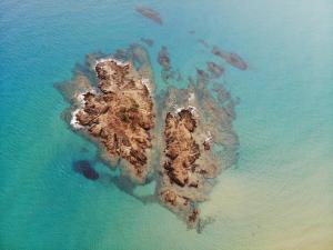 una vista aerea di una piccola isola nell'oceano di Eco Village Baia Delle Ginestre a Teulada
