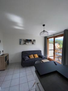 a living room with a couch and a table at Studio entre lac entre montagnes in Saint-Sauveur