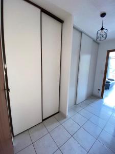 a room with white sliding doors and a tile floor at Studio entre lac entre montagnes in Saint-Sauveur