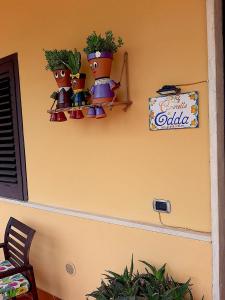 una pared con tres macetas de flores y un cartel en ella en Le Camerette di Edda, en Cassino
