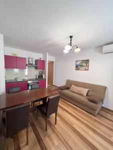 uma sala de estar com uma mesa e um sofá em APARTMANI PALME em Funtana