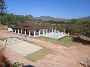 Cette chambre offre une vue sur une maison dotée d'une piscine. dans l'établissement Chácara do vô Meireles, à Serra Negra