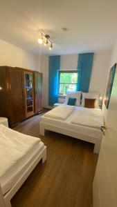 Habitación con 2 camas, paredes azules y suelo de madera. en Waldzauber, en Waldkirchen
