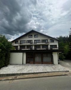 a large white house with a garage at Chalet Minut in Vatra Dornei