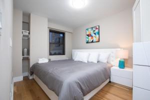 ニューヨークにあるCozy Apartment in Upper East Sideの白い部屋に大型ベッド1台が備わるベッドルーム1室が備わります。