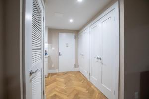 a hallway with white doors and a wooden floor at Cozy Apartment in Upper East Side in New York