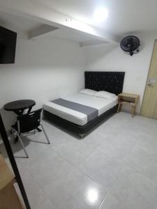 a bedroom with a bed and a desk and a chair at Hotel Urbano 70 in Medellín