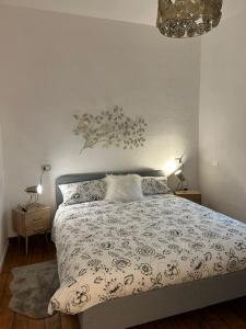 1 dormitorio con 1 cama, 2 lámparas y lámpara de araña en Casa Blanche, en Fanano