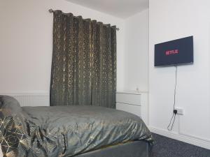 Kunda House Oliver في برمنغهام: غرفة نوم بسرير وستارة سوداء