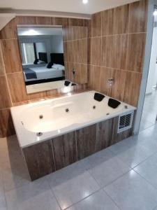 a bath tub in a room with a bedroom at Hotel Urbano 70 in Medellín