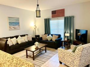 a living room with couches and an american flag at Townhouse in Paradise Palms, Kissimmee in Kissimmee