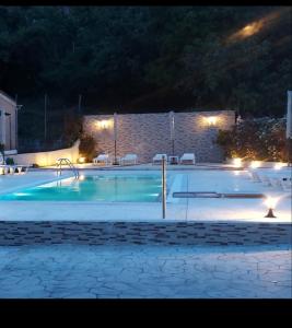 a swimming pool at night with lights at Spiridoula's Apartments Corfu in Perama