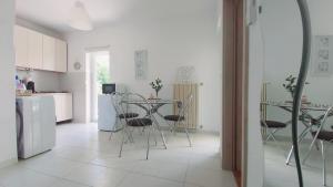 a white kitchen with a table and chairs in it at Apartments Lidija in Umag