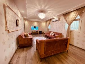 een woonkamer met 2 banken en een tv bij شقة فندقية استديو بطحاءقريش مكة in Mekka