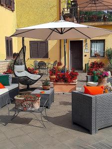 a patio with tables and an umbrella and flowers at La casetta di Simone in Cassino