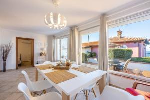 comedor con mesa y sillas y ventana grande en Apartments Villa Dora, en Kraljevica