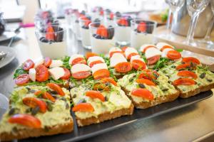 a tray with several slices of bread with tomatoes and cheese at Amenity Hotel & Resort Lipno in Lipno nad Vltavou