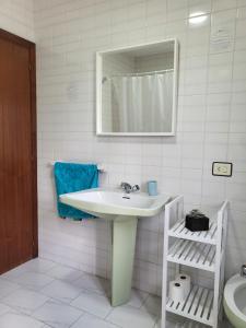 y baño con lavabo, espejo y aseo. en Casa Bascuas, en Portonovo