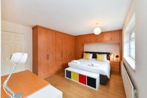 a bedroom with a white bed and wooden cabinets at Lambourne House in Nottingham