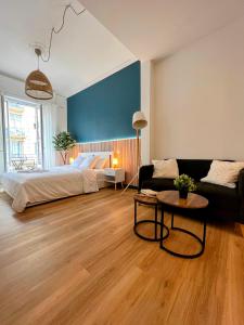 a living room with a bed and a couch at Sunshine Getaway - Stylish Studio in the Heart of Nice in Nice