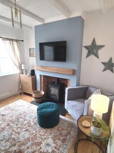 a living room with a fireplace and a tv on the wall at Martha's cottage by the sea in Gorleston-on-Sea