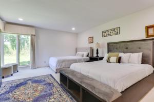 two beds in a bedroom with a large window at Spacious Buffalo Brick Home w/ Backyard! in Buffalo +32 photos