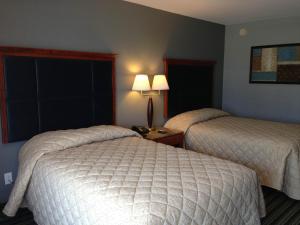 a hotel room with two beds and a window at Safari Inn - Murfreesboro in Murfreesboro