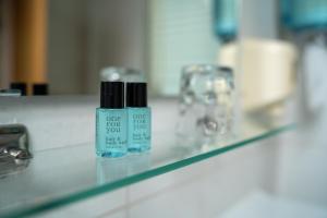 a bottle of one foot lotion sitting on a bathroom sink at Accomo Apartmanház in Siófok +27 photos