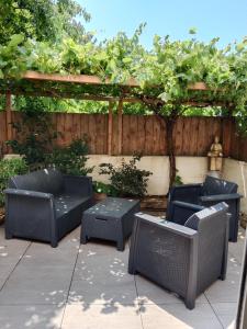 eine Terrasse mit 3 Stühlen und einer Pergola mit einem Baum in der Unterkunft Maison de charme in Audenge