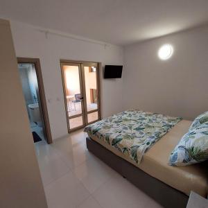 1 dormitorio con cama y vistas a un balcón en 5 rooms apartman en Barbat na Rabu