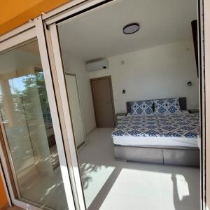 1 dormitorio con 1 cama y puerta corredera de cristal en 5 rooms apartman en Barbat na Rabu