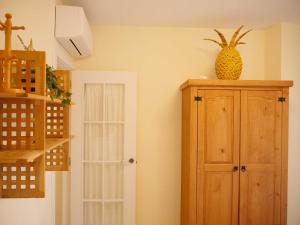 una stanza con un mobile in legno con sopra un ananas di Apartamento Guadiana Sol a Estepona