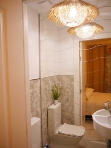 bagno con servizi igienici, lavandino e lampadario pendente. di Apartamento Guadiana Sol a Estepona