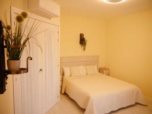 una camera con un letto bianco e una pianta di Apartamento Guadiana Sol a Estepona