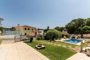a backyard with a swimming pool and a house at BmyGuest - Lagoa Beach & Pool Villa in Lagoa de Albufeira