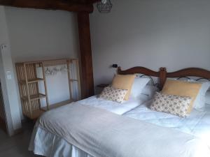 a bedroom with a bed with white sheets and pillows at Casa Rural Triticum in Navas de Bureba