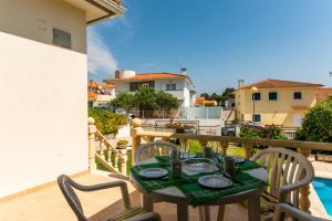 a table and chairs on the balcony of a house at BmyGuest - Lagoa Beach & Pool Villa in Lagoa de Albufeira