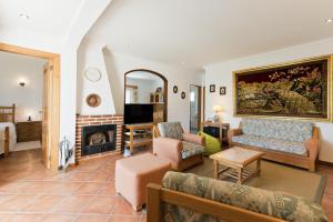 a living room with a couch and a fireplace at BmyGuest - Lagoa Beach & Pool Villa in Lagoa de Albufeira