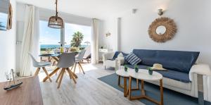 ミハスにあるSeafront Beach house Rocas del Marの青いソファとテーブルのあるリビングルーム