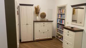 Habitación con estante de libros y armario blanco en Waldzauber, en Waldkirchen